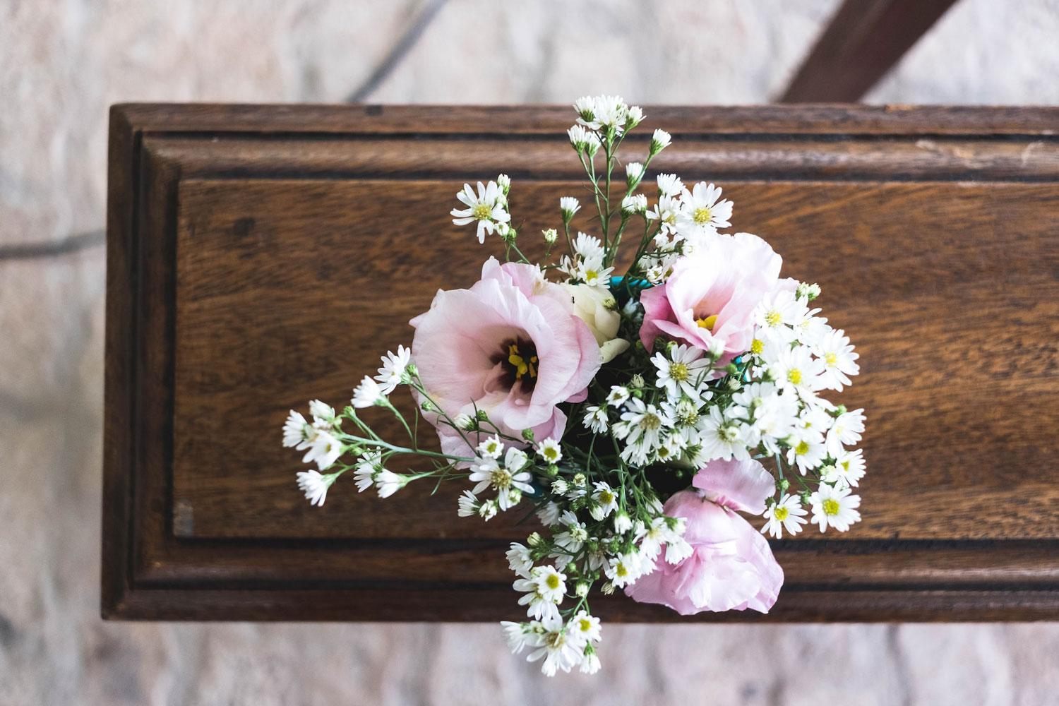 flores rosas em cima de um caixão durante o velório de um ente querido