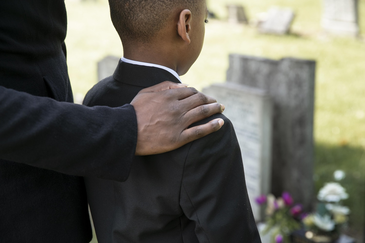 Uma imagem de uma criança visitando o túmulo de um ente querido