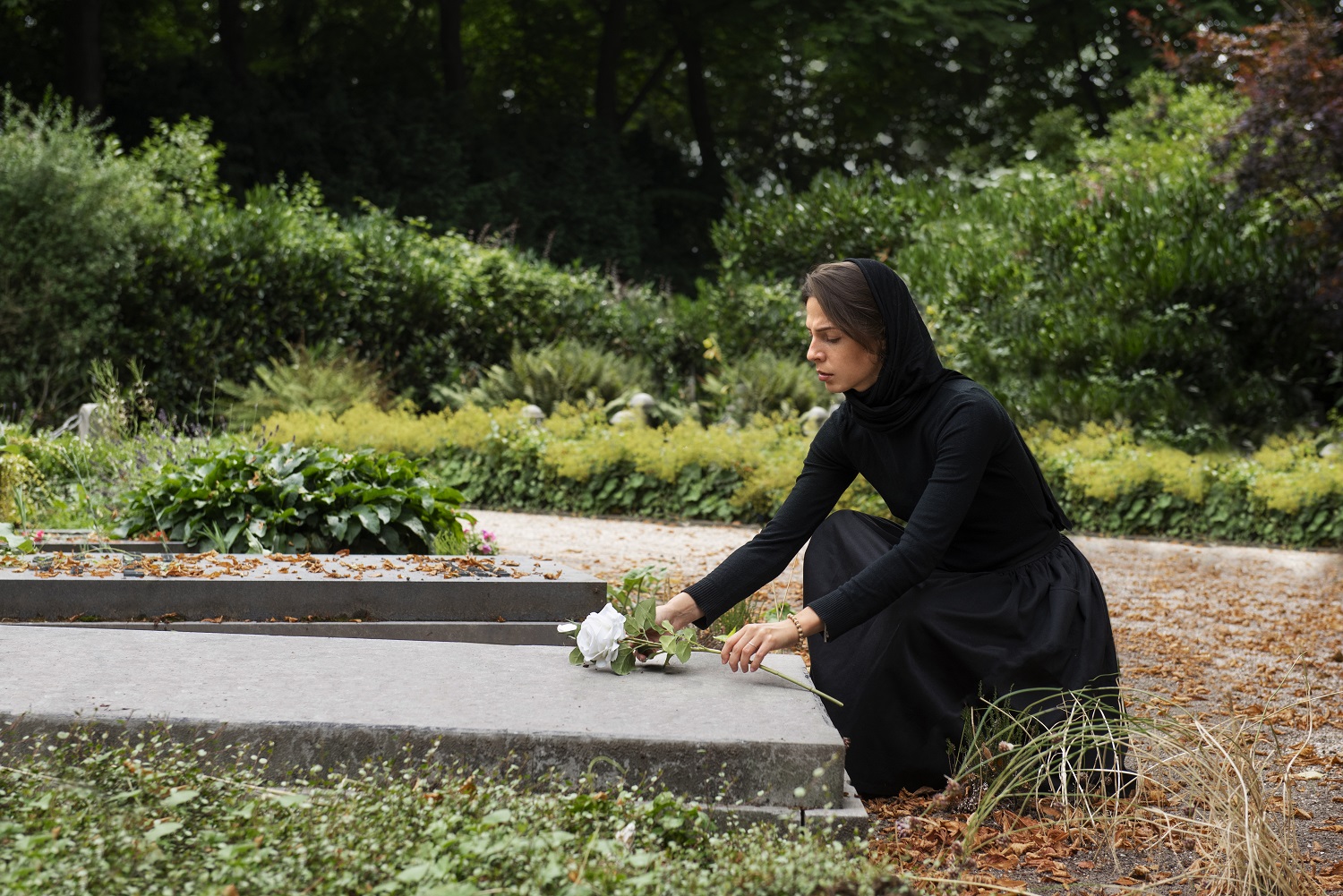 Uma imagem de uma moça de preto em um cemitério pensando no que acontece depois da morte.