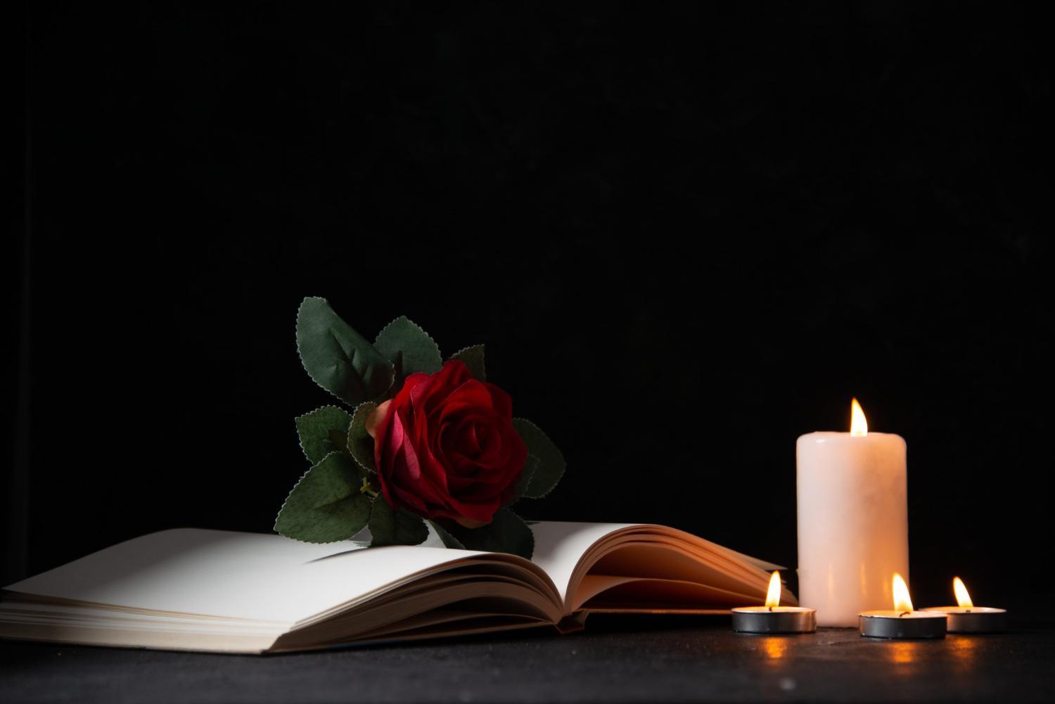 Uma foto de velas acesas com livro sobre luto