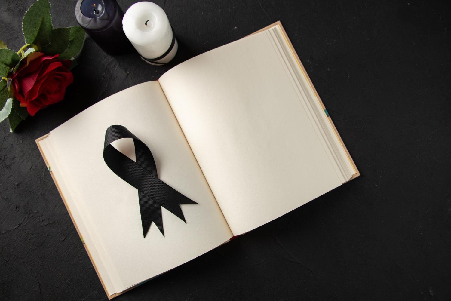Imagem de um livro aberto com laço de luto preto